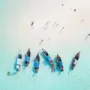 Aerial view of beach with longtail boats and a sandbar